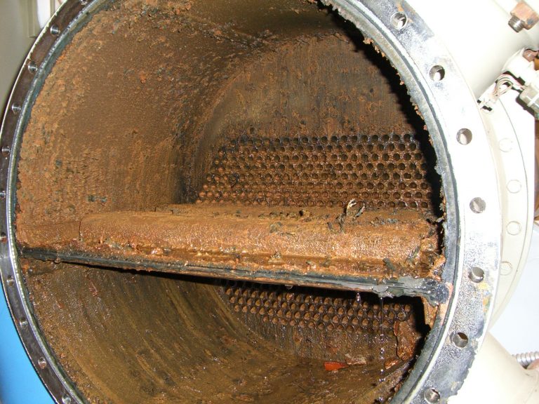 A chiller or heat exchanger used in HVAC systems showing fouling and corrosion within the tubes and shell.