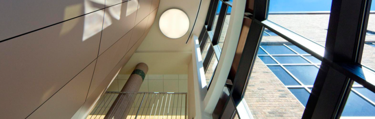 A modern building interior, possibly a library or civic center, from the dramatic perspective of looking up.