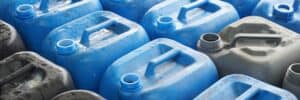 Rows of blue of grey chemical jugs, most likely containers used to hold liquid water treatment chemicals.