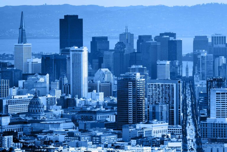 A picture of the San Francisco skyline featuring building with a glass facade, stylized with a blue and sepia tone.